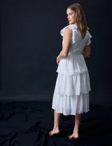 Vestido blanco de gasa con capas de la marca Julia Jordan. Tiene escote en V, mangas cortas con volados, corte en la cintura, abertura central en la espalda con cierre invisible y forro interno a tono.