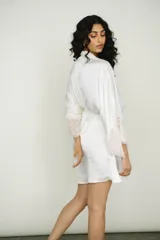 Bata corta color blanco de seda con mangas anchas terminadas en encaje. Incluye lazo de seda para ajustar en la cintura.