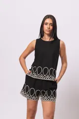 Musculosa negra simil lino con detalle de bordado blanco en el ruedo.