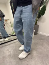 Pantalón de jean celeste claro, corte baggy, con roturas y desgaste.