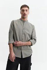 Camisa azul de manga larga con cuello mao y cartera abotonada.