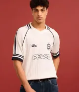 Camisa polo de punto color blanco con rayas azul marino en cuello y mangas. Tiene bordados localizados y lettering.