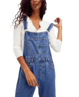 Jardinero de denim azul con silueta holgada, bolsillos delanteros, laterales y traseros, tirantes ajustables con enganche clásico y cierre lateral de botones.