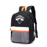 Mochila negra con detalles en blanco, naranja y gris. Presenta el logo de los New York Knicks en el frente y un parche circular con el logo de los Detroit Pistons en el bolsillo inferior. Incluye un pequeño logo de la NBA en el lateral.