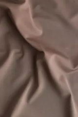 Body color marrón topo, de punto elástico suave, con escote redondo, breteles anchos y corte colaless. Tiene botones a presión ocultos en la entrepierna y está parcialmente forrado.
