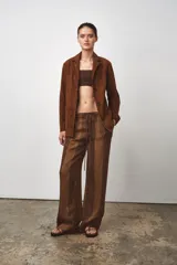 Pantalón de tiro medio confeccionado en hilatura de lino 100%. Cintura con elástico en espalda ajustable con cordones. Bolsillos laterales ocultos en costura y de plastrón en espalda.