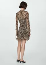 Vestido corto con estampado animal print, cuello redondo y mangas largas con lazos en los puños.