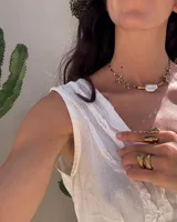 Collar corto con cuentas de piedra natural multicolor, perlas de río irregulares y dijes de bronce con forma de coral.