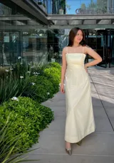 Vestido midi a rayas verticales color blanco y amarillo, con breteles finos y corte recto.