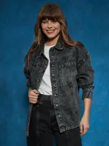 Sobrecamisa negra de denim con cuello clásico, cierre frontal con botones a presión, mangas largas con puños abotonados, dos bolsillos con solapa en el pecho y corte holgado.