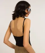 Blusa sin mangas, con frente única confeccionada en bengalina color negro. La prenda tiene escote v y breteles ajustables.