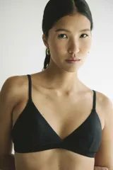 Top de bikini negro, de corte triangular clásico, con tirantes finos y copas removibles.