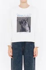 Sudadera blanca de algodón con cuello redondo y mangas largas. Estampado frontal con el logo de la marca y la imagen de un perro chihuahua.