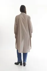 Camisa color beige de manga larga con cuello clásico, cierre frontal con botones y bajo irregular.