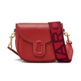 Cartera Marc Jacobs modelo The Saddle Bag, confeccionada en cuero color rojo. Presenta cierre magnético, bolsillo interno y correa de tela con el logo de la marca.