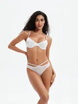Conjunto de bikini blanco de tela brillante, compuesto por un corpiño con aro y breteles finos y una bombacha con tiras cruzadas en la cadera.