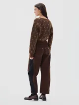 Jean barrel colorblock de denim azul marino y pana bordó, con pierna ancha que se estrecha hacia el tobillo. Presenta cintura ajustada y corte relajado en cadera y muslo.