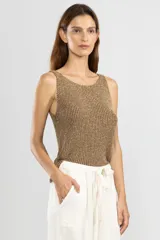 Musculosa sin mangas tejida en Italia en punto canalé con mezcla de viscosa e hilos metálicos Lurex color dorado. Con escote bote y calce cómodo.