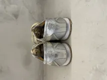 Championes urbanos plateados de cuero, con cordones y suela blanca.