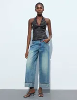 Top negro con cuello halter y espalda descubierta, con apliques de tachas plateadas.