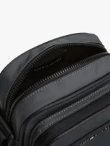 Cartera tipo bandolera Tommy Hilfiger color negro, con correa ajustable con inscripción tonal de la marca, cierre de cremallera, bolsillo interior abierto, bolsillo exterior con cremallera y logo metálico en el frente.