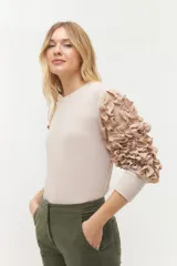 Remera negra de punto con mangas largas abullonadas con volantes.