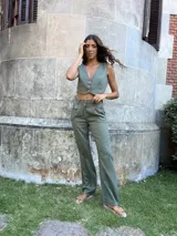 Pantalón verde de lino de corte recto con bolsillos laterales y cierre frontal con botón.