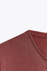 Camiseta marrón de algodón con cuello redondo, corte recto y mangas cortas. Tiene un efecto de lavado que le da un aspecto vintage.