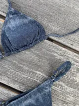 Conjunto de bikini con estampado tie-dye en tonos azul y blanco. El corpiño es de triángulos movibles con tiras para atar al cuello y espalda, y almohadillas desmontables. La bombacha es vedetina con tiritas regulables con hebilla a los costados.