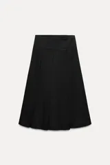 Falda midi negra de tiro medio confeccionada en hilatura con lana. Diseño con tablas y cierre con cremallera oculta en costura.