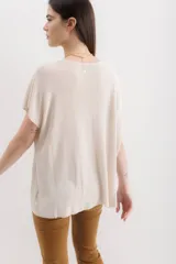 Blusa color beige de tejido de punto con lurex, de mangas cortas y corte holgado.