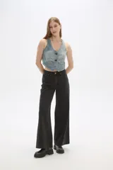 Chaleco de jean celeste sin mangas, con cuello en V, cierre frontal con botones y dos bolsillos con solapa en el pecho.