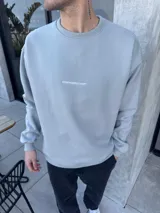 Buzo gris de algodón con corte oversize y bordado pequeño con la leyenda "BOHEMIANDESIGN" en el pecho.
