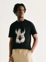 Camiseta blanca de algodón con cuello redondo y mangas cortas. Estampa rectangular con borde negro que contiene la frase "NATURAL ATMOSPHERE" en letras mayúsculas y una imagen de montañas y mar.