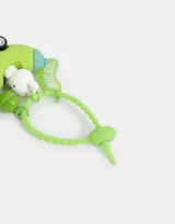 Llavero con forma de auto verde con un conejo blanco como conductor, una campana verde y un cartel con la palabra 'NICE!' en verde y amarillo. Tiene un precinto regulable verde.
