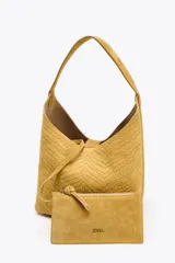 Bolso de hombro amarillo con cuerpo en relieve efecto trenzado, asa de hombro, cartera interior con cierre mediante cremallera metálica, base rígida con tachas y cierre mediante botón imantado.