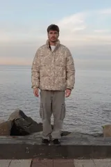 Campera puffer de corderoy con estampado paisley en tonos beige y cuello alto.