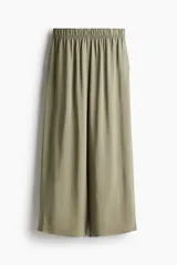 Pantalón tobillero color verde oliva de viscosa con caída suave, tiro alto con elástico en la cintura, bolsillos laterales y piernas amplias rectas.