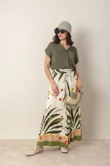 Pantalón palazzo de viscosa color crudo con estampado de hojas y flores en tonos azules y marrones. Cintura elastizada en la parte trasera.
