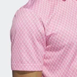 Chomba de golf Adidas color rosa con estampado de rombos y logo blanco en el pecho.