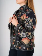 Chaqueta negra con bordados florales de colores, corte recto y cuello mao.