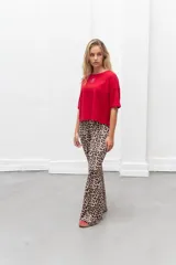 Conjunto de sweater color beige de corte holgado y pantalón acampanado con estampado animal print.