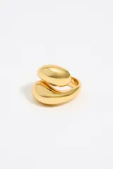 Anillo dorado de metal con diseño en espiral y logo grabado.