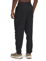Pantalón cargo Under Armour color beige, de corte ajustado, con bolsillos laterales con cierre y detalles en negro.