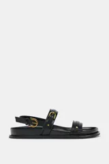 Sandalias planas negras con tiras y hebillas.