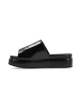 Sandalia de cuero color negro con tira ancha sobre el empeine, ajuste con velcro y aplique metálico circular.