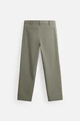 Pantalón chino negro slim fit confeccionado en tejido técnico de secado rápido. Cuenta con bolsillos frontales y traseros de vivo. Cierre frontal con cremallera y botón.