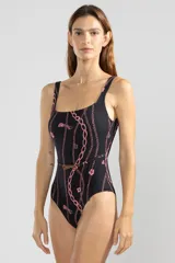 Traje de baño enterizo negro con estampado de cadenas y tigres rosas. Tiene escote cuadrado, breteles anchos y cinturón blanco con hebilla dorada en forma de tigre.