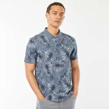 Remera polo de piqué de algodón color azul con estampado de hojas en blanco y negro.