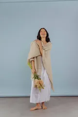 Ruana de lana merino color beige, tejida a mano con detalles de brillos y flecos.